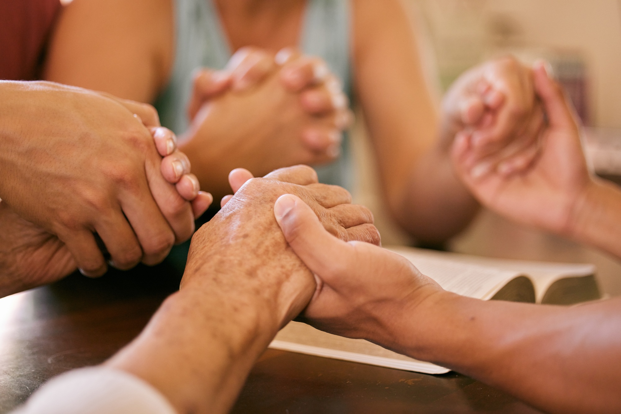 Shot of a group of people holding hands in prayer